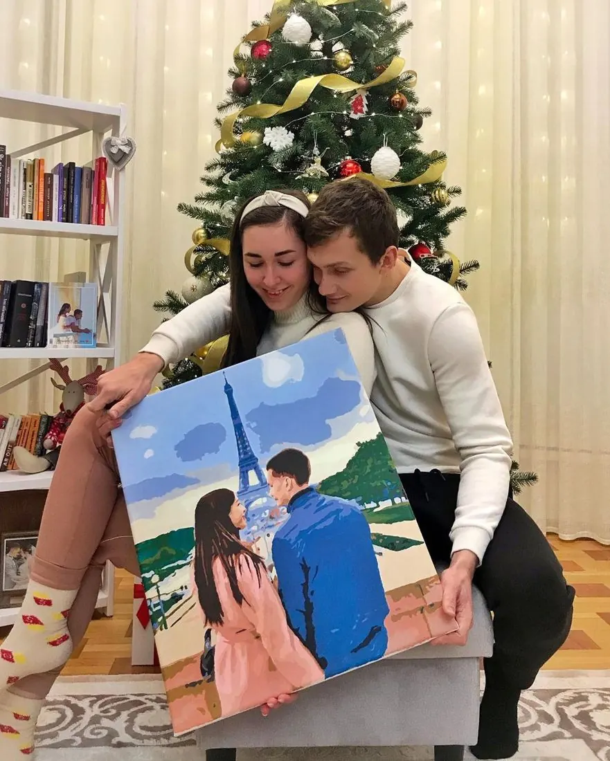 Пара з картиною за номерами біля ялинки