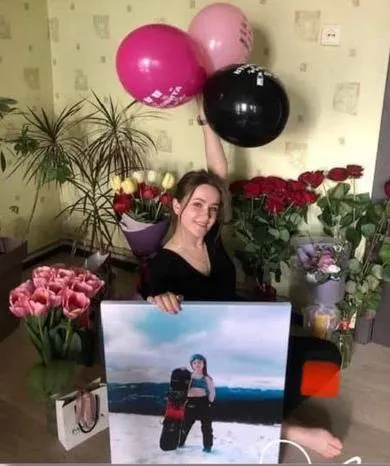 Іменинниця з картиною на полотні серед квітів і кульок